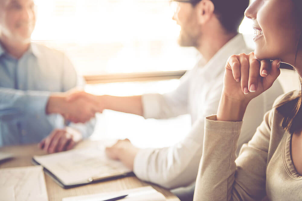 A solicitor and a couple shaking hands