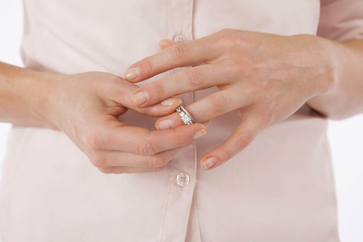 A women going through a divorce removing her wedding ring