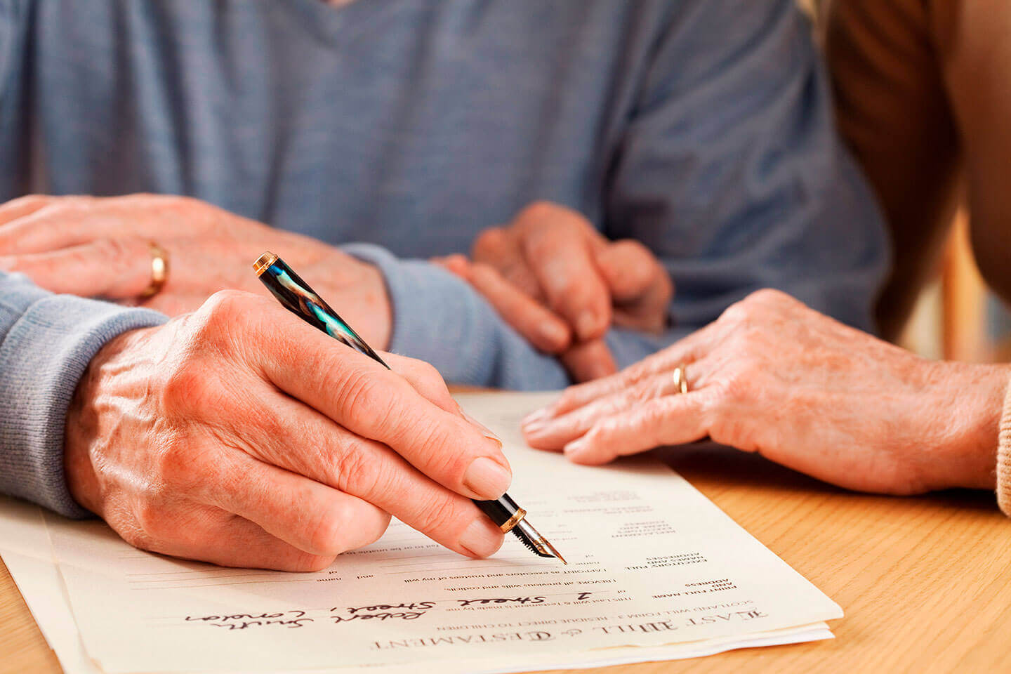 Elderly man signing a legal document