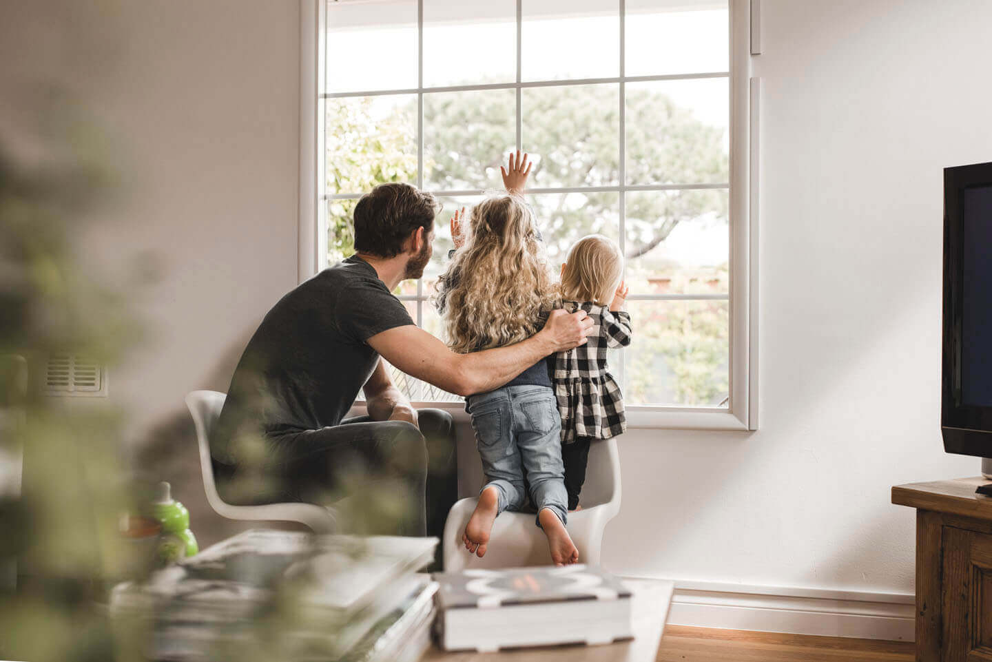 A father and his two children looking out the window