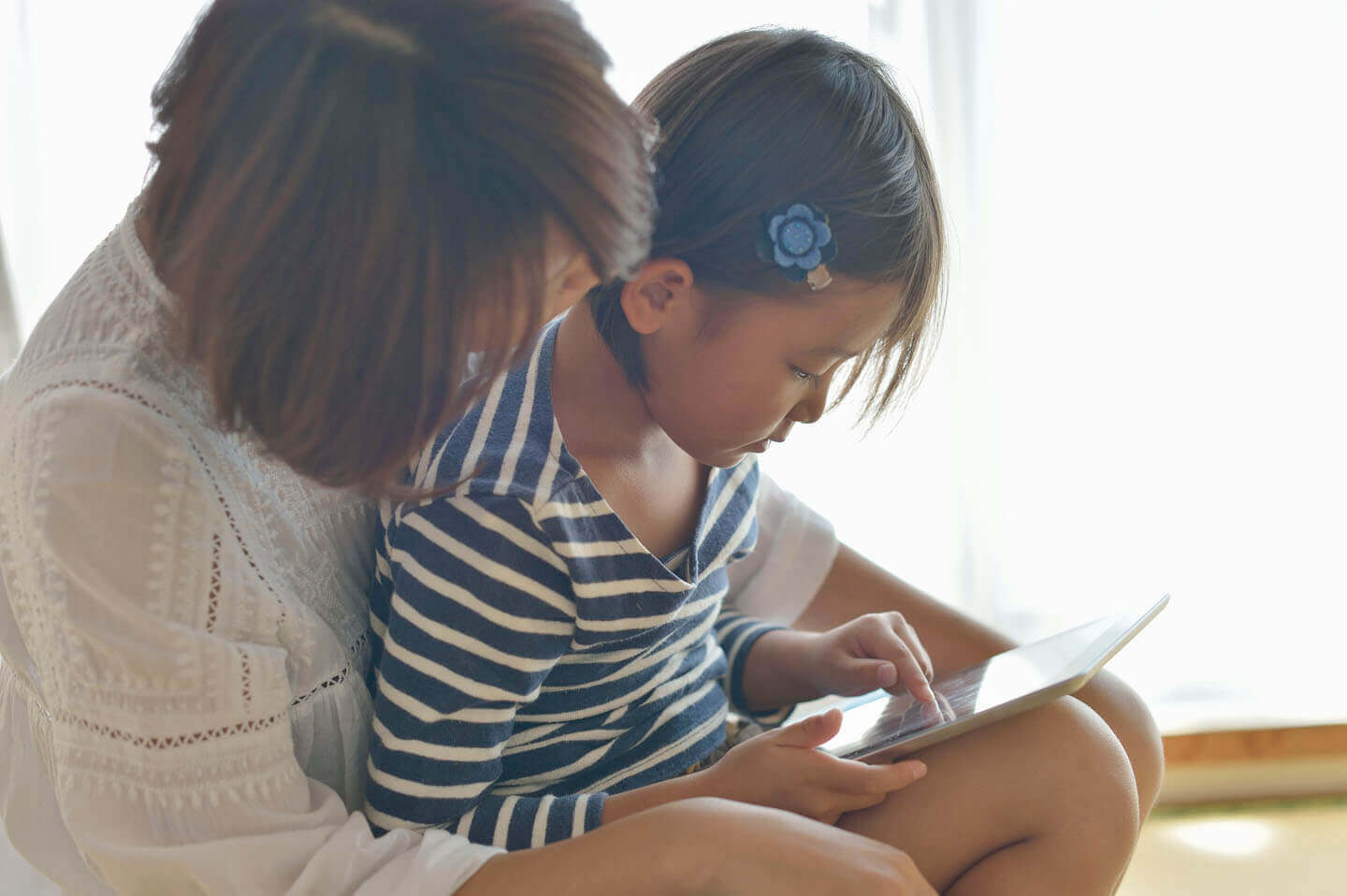 A mother and daughter using a tablet together