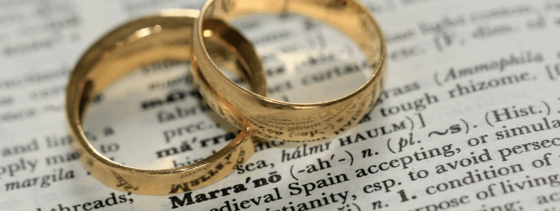 two wedding rings resting on a page of a Spanish dictionary